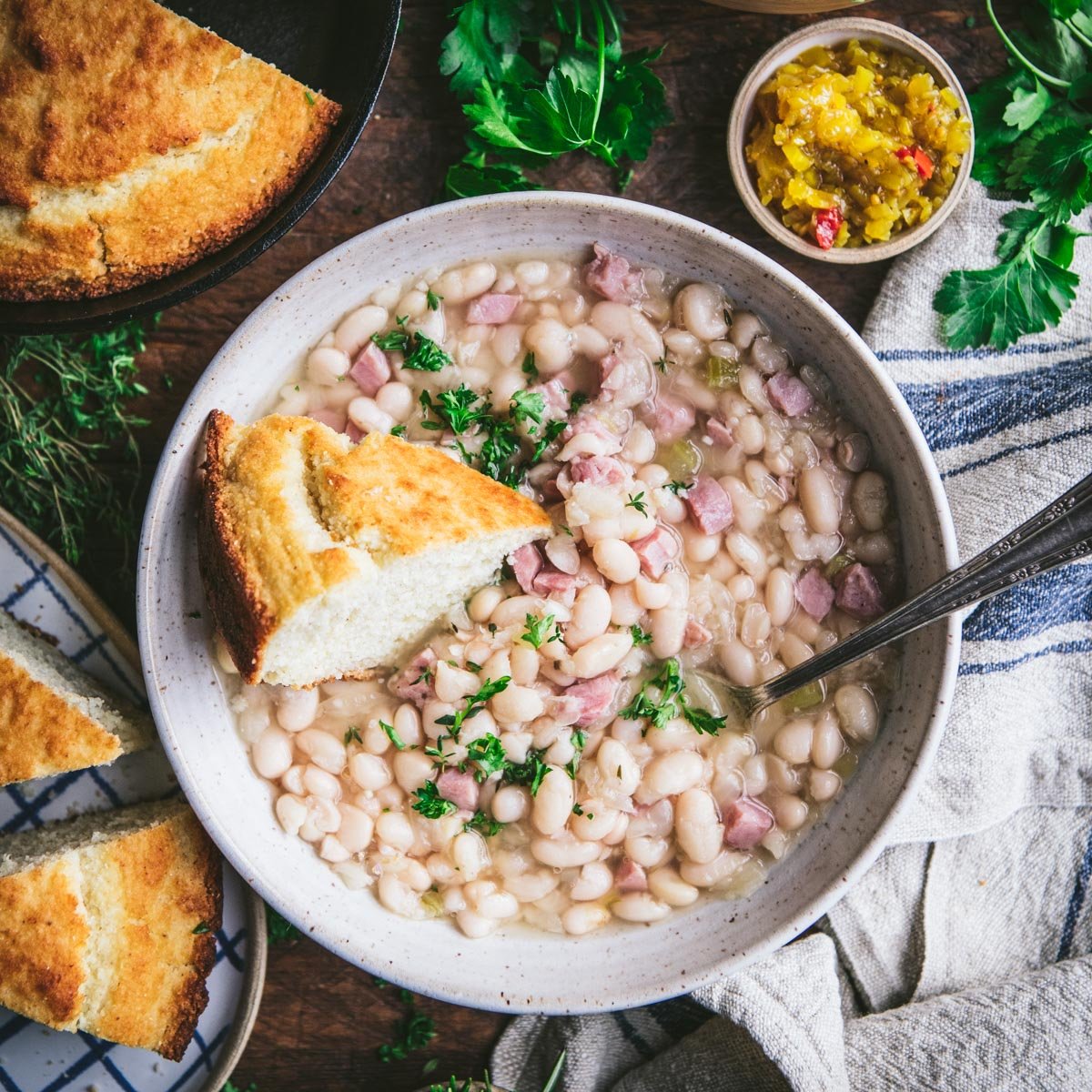 Southern ham and beans in a bowl with a side of cornbread.