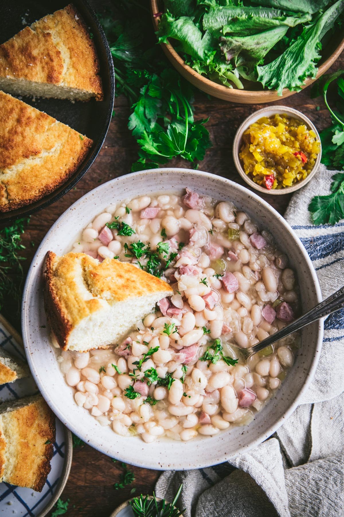 Overhead shot of a bowl of ham and beans with cornbread.