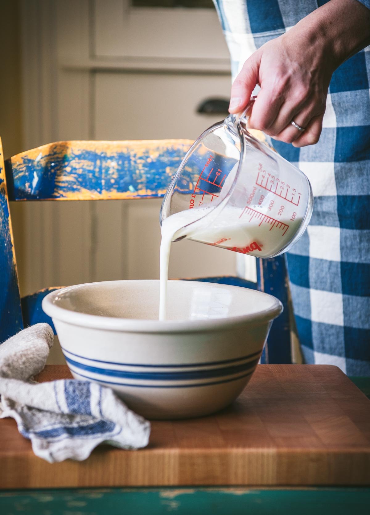 Pouring buttermilk into a bowl.