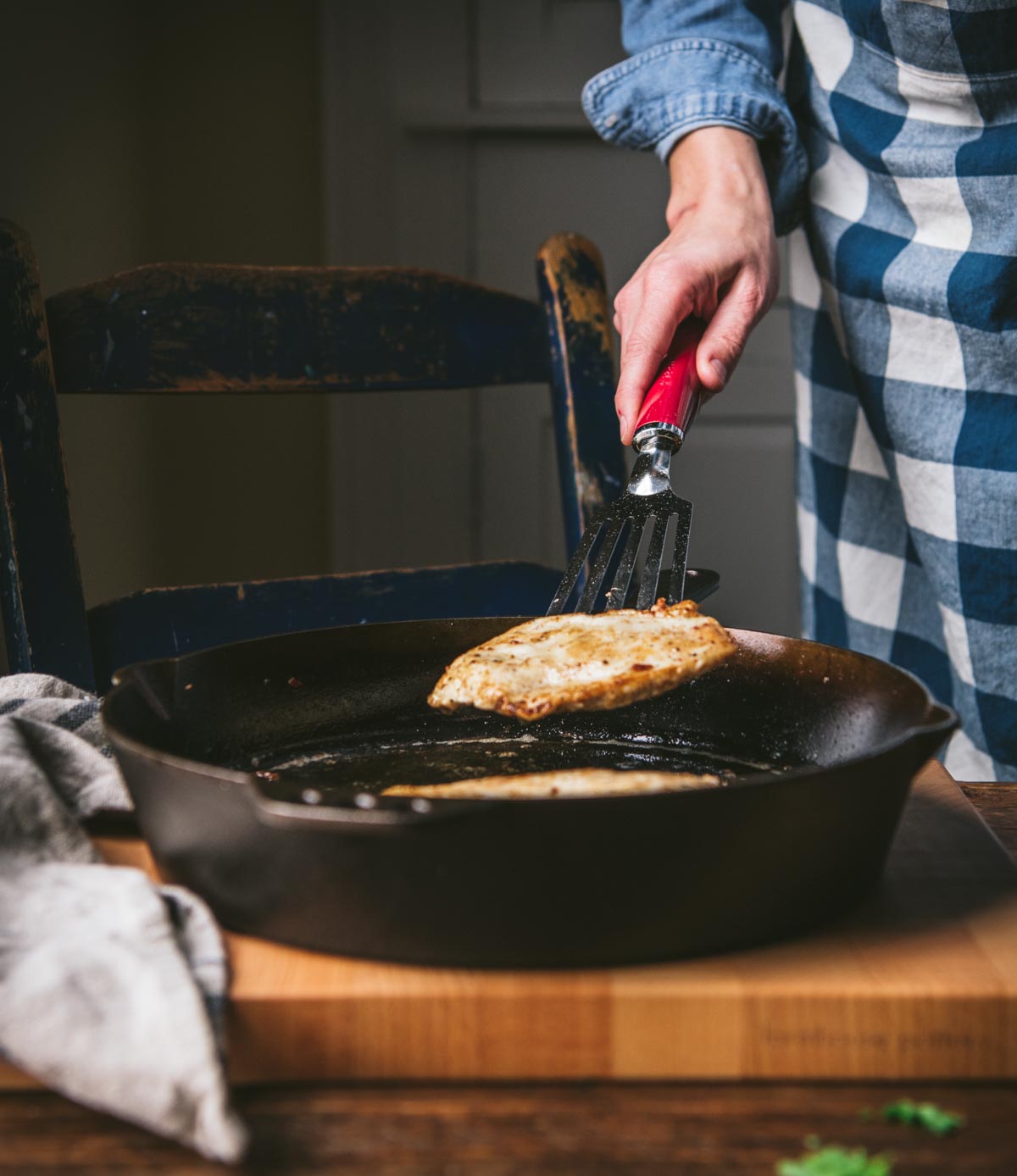Searing chicken cutlets in a skillet.