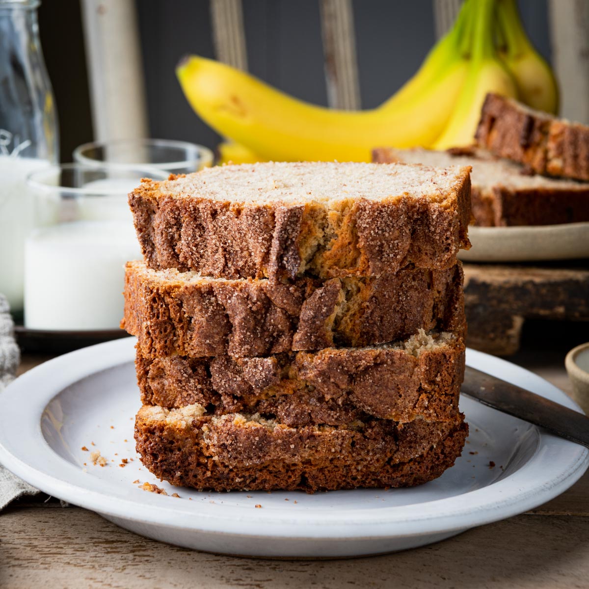 Square front shot of four slices of buttermilk banana bread on a plate