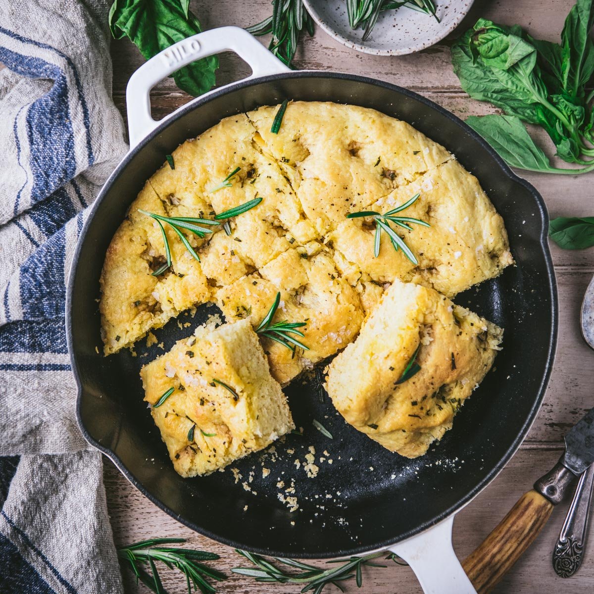 Square overhead shot of a cast iron skillet full of sliced focaccia