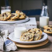 Square side shot of chocolate chip pudding cookies on a table with milk