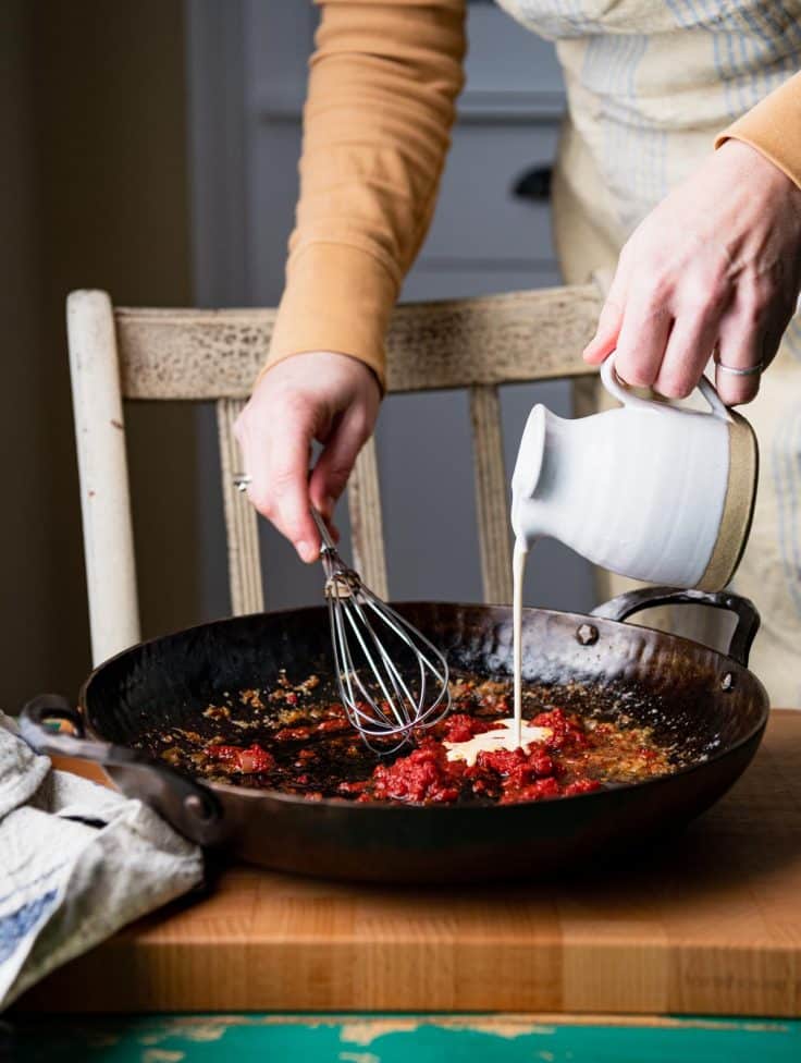 Process shot showing how to make creamy tomato sauce for pasta.