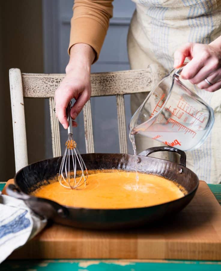 Process shot showing how to make creamy tomato pasta sauce.
