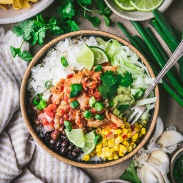 Square overhead image of a crock pot chipotle chicken bowl on a table
