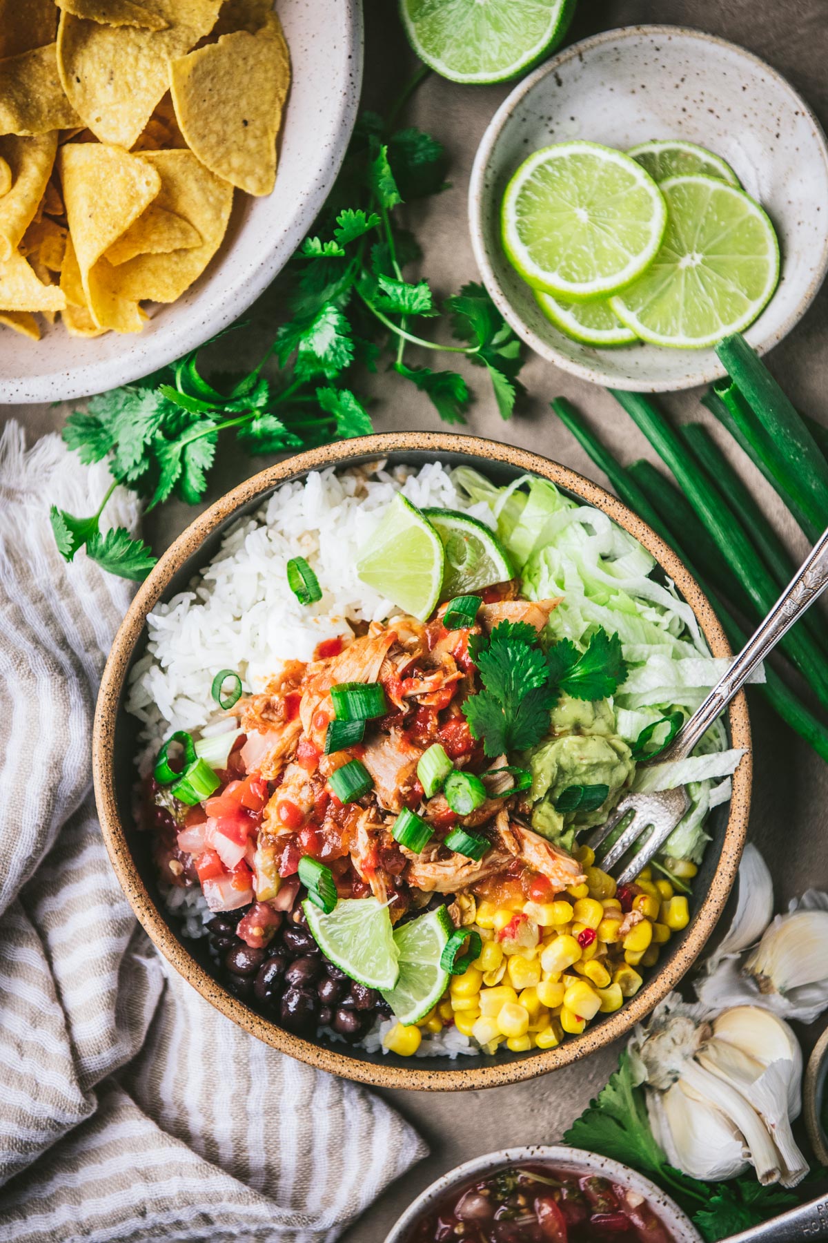 Chipotle chicken bowl with rice and toppings on a table.