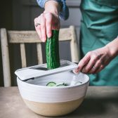 Process shot showing how to make cucumber radish salad.