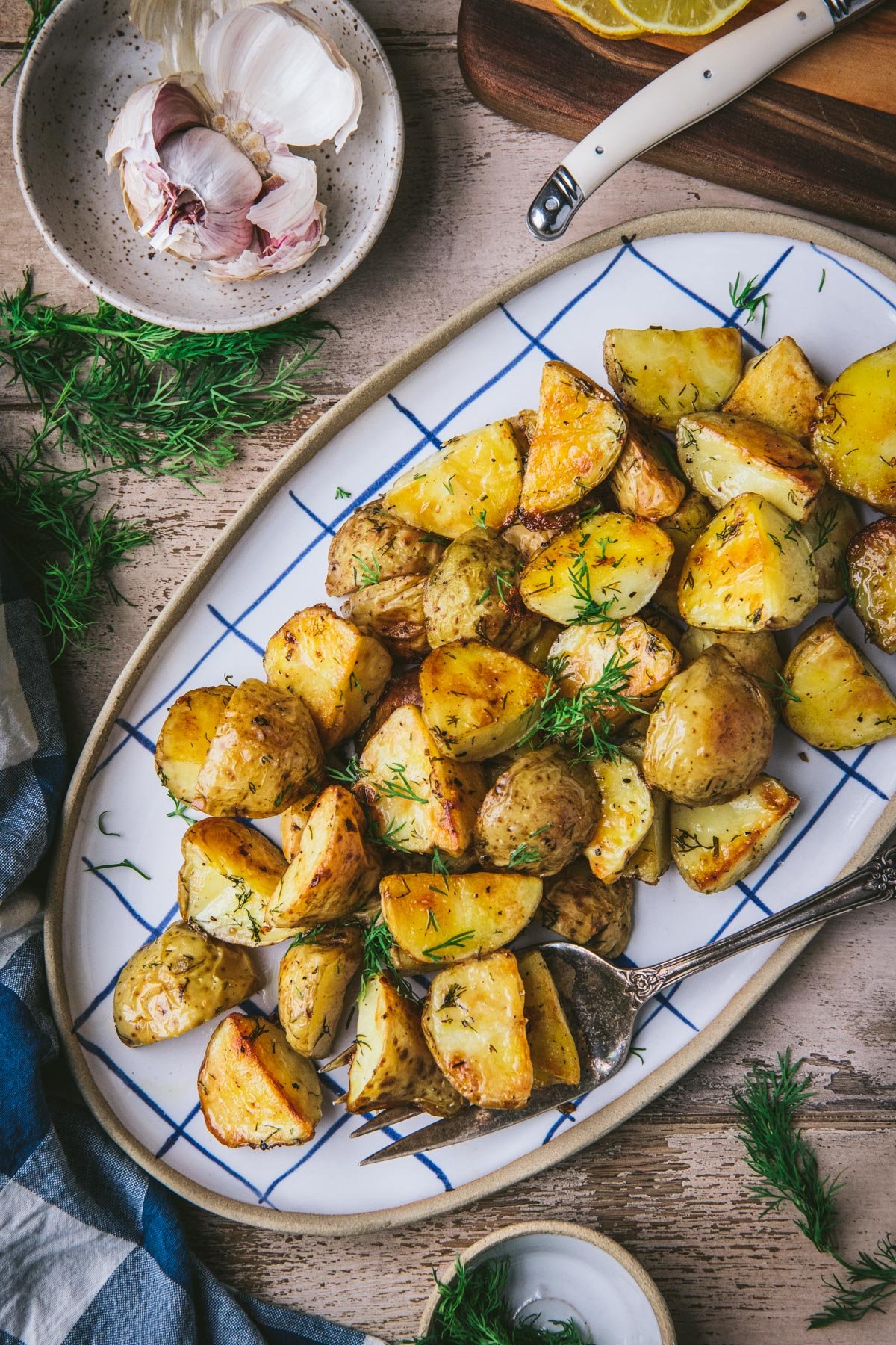 Crispy roasted potatoes with dill on a serving tray