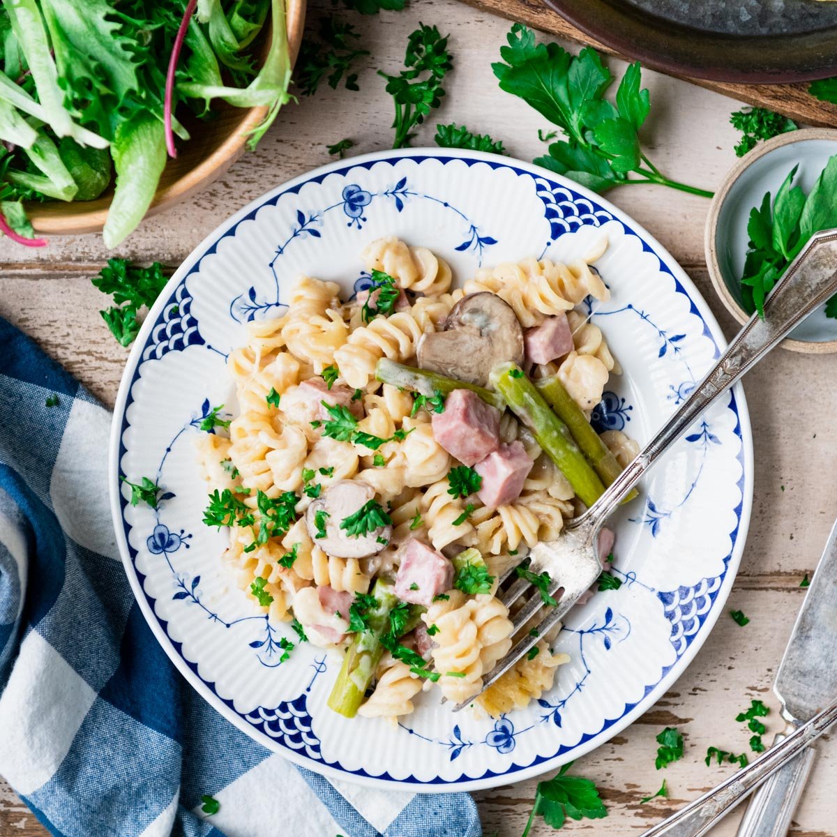 Pasta with ham and asparagus and mushrooms on a plate