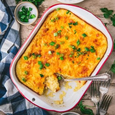 Square overhead shot of cheese grits casserole in a vintage enamelware pan
