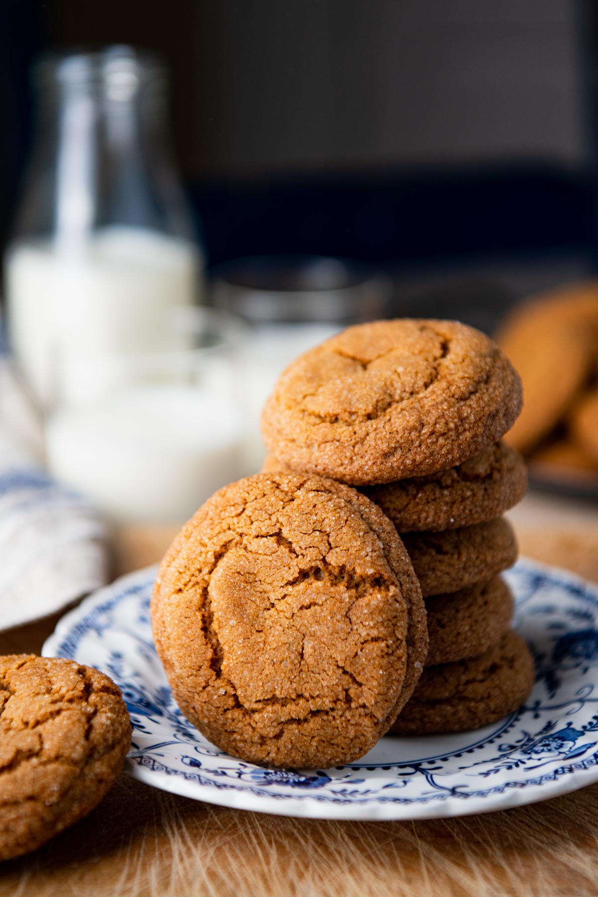 Plate of chewy ginger molasses cookies on a table with milk