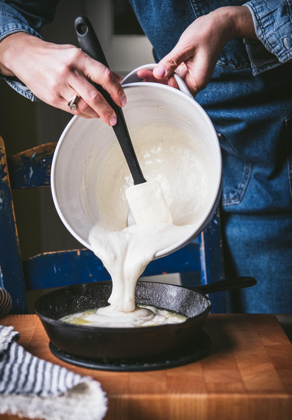 Pouring batter into a cast iron skillet.