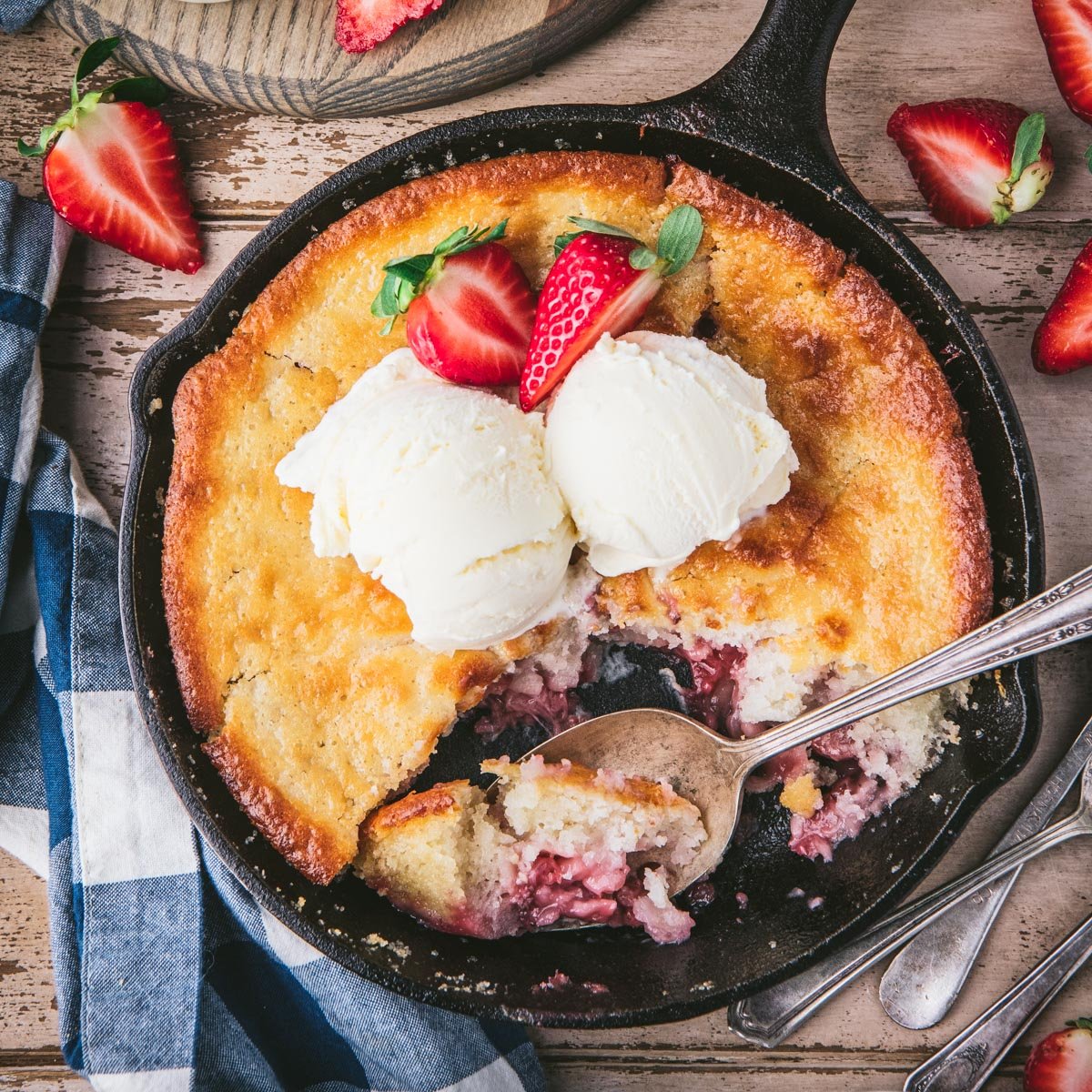 Square overhead shot of a skillet of old fashioned strawberry cobbler.