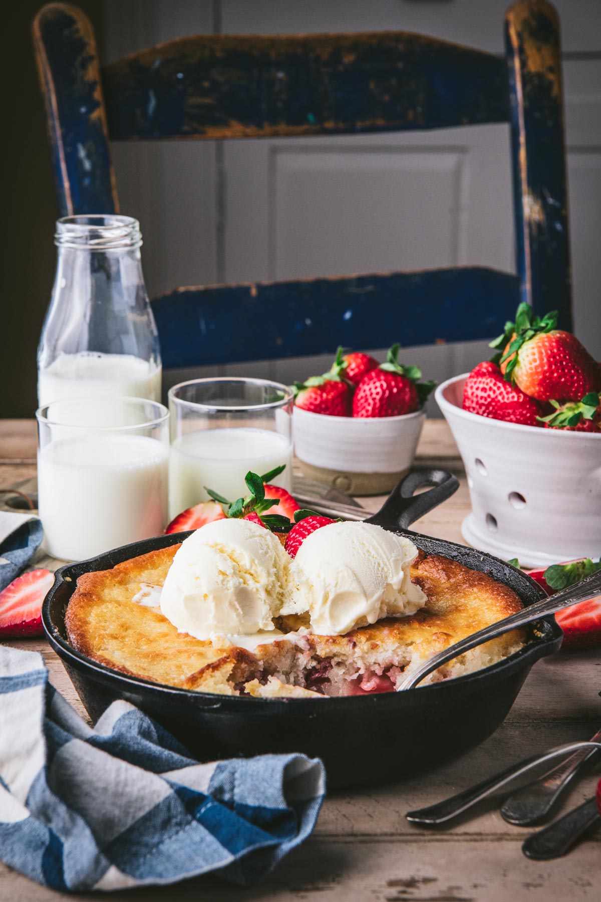 Side shot of the best strawberry cobbler recipe in a cast iron skillet on a table.