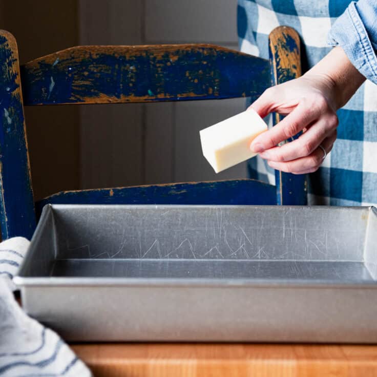 Placing the butter in the cake pan.