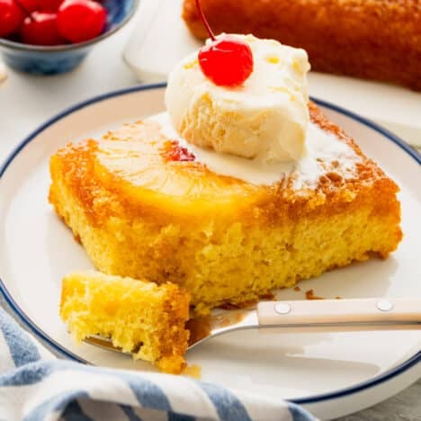Square shot of a slice of pineapple upside down cake with cake mix on a plate.
