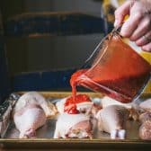 Pouring glaze over chicken parts.