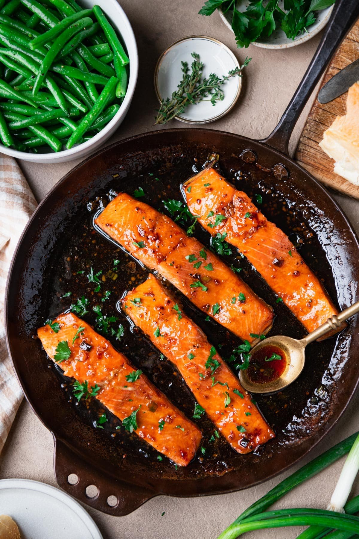 Overhead shot of a skillet of bourbon glazed salmon on a table.