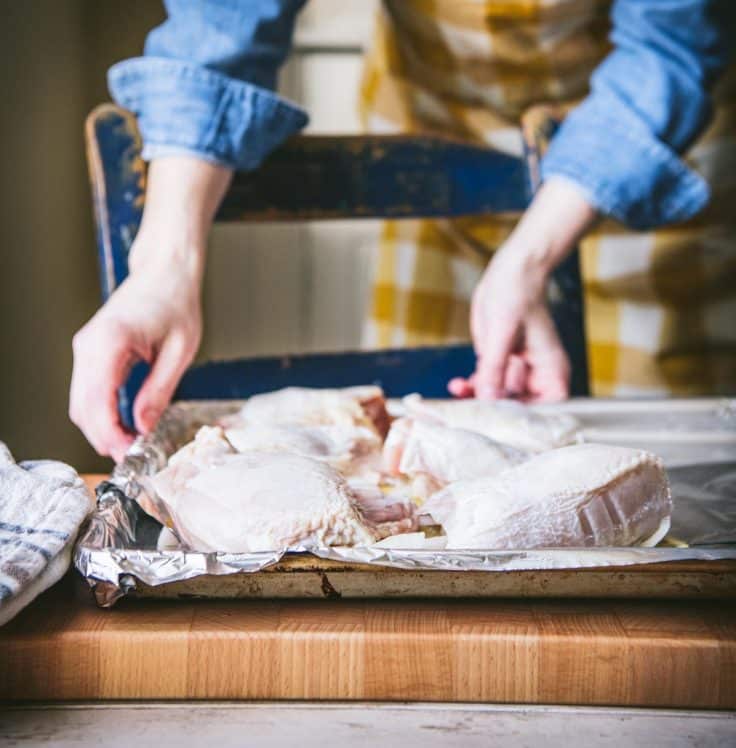 Process shot showing how to make Greek chicken and potatoes.