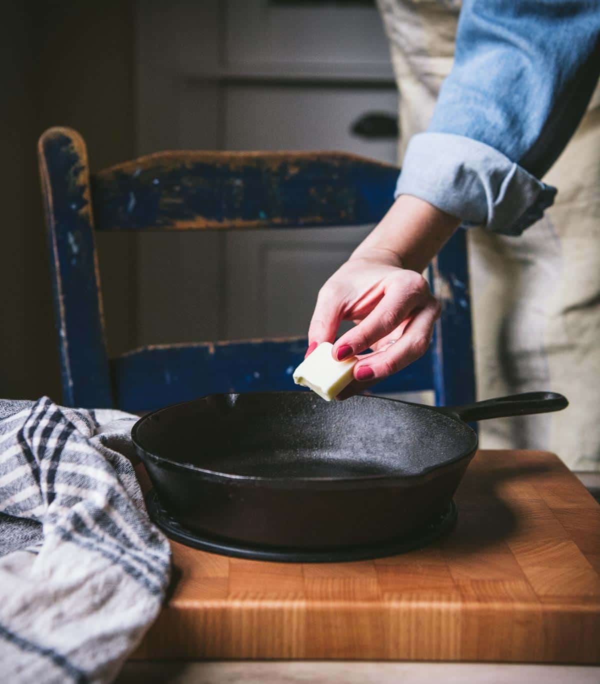 Adding butter to a hot cast iron skillet.