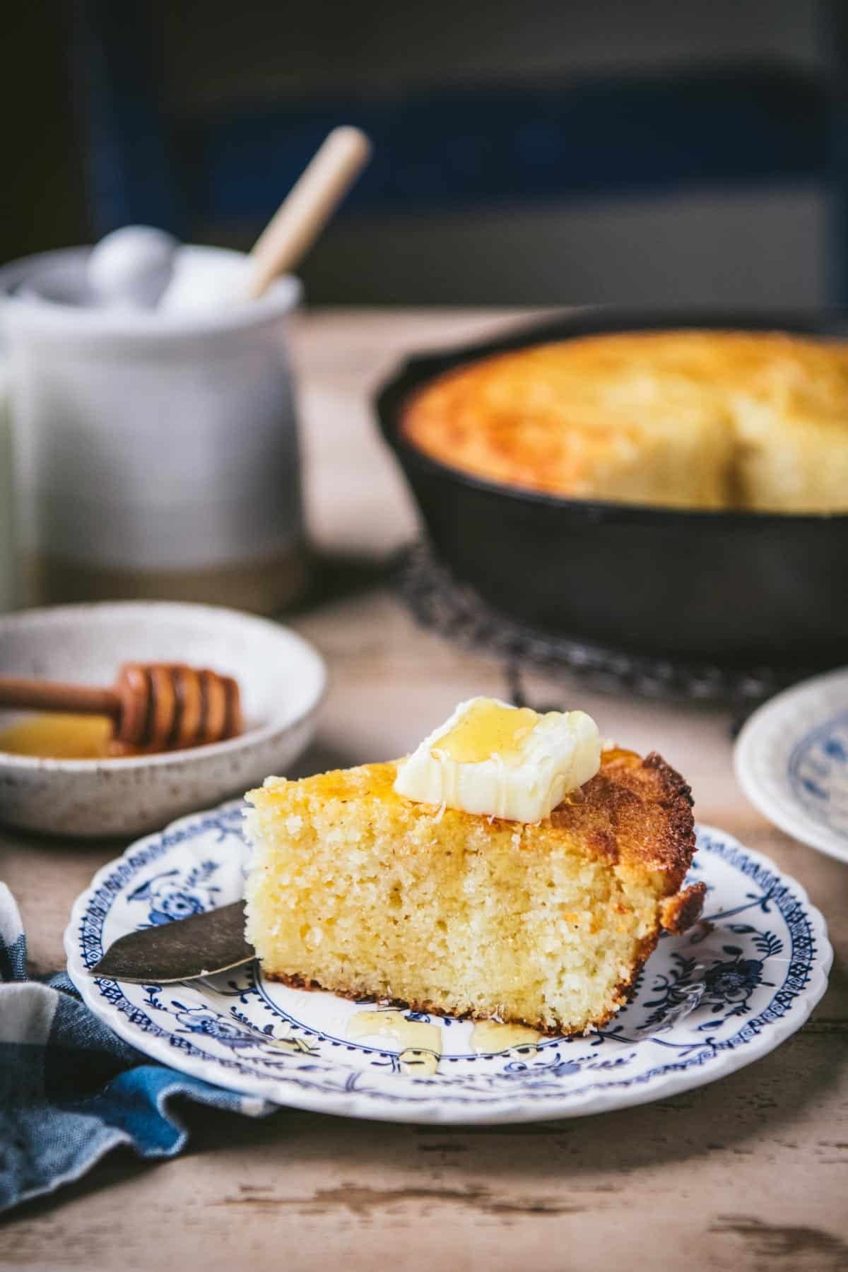 The best honey butter cornbread recipe served on a blue and white plate.
