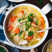 Square overhead shot of a bowl of lemon chicken orzo soup