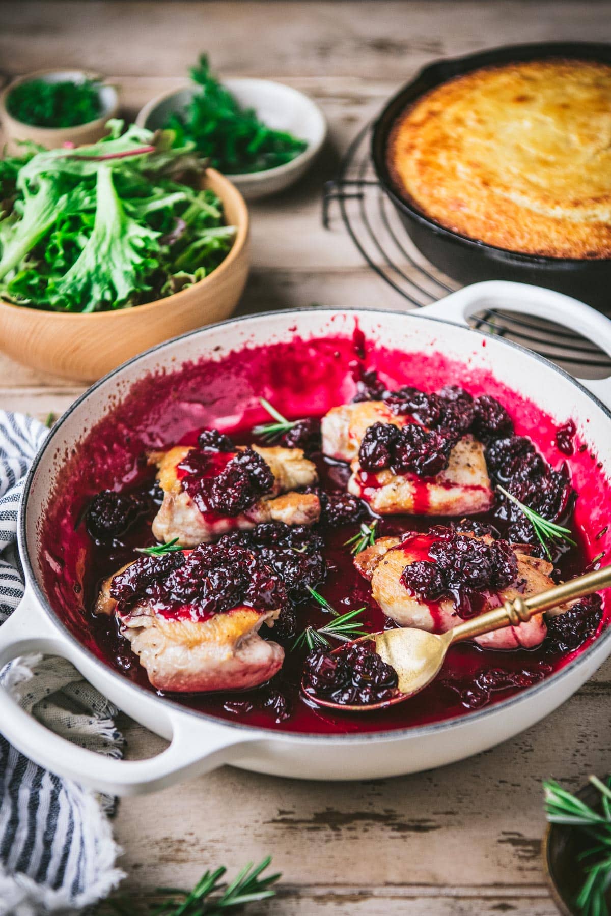 Side shot of a skillet of blackberry chicken on a table