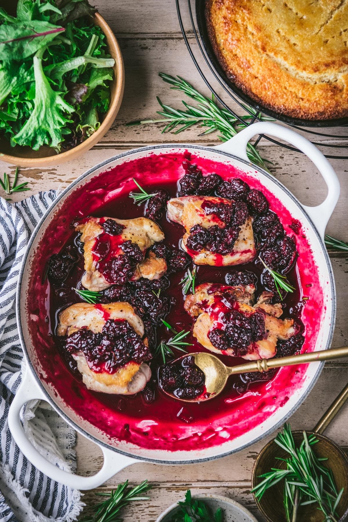 Blackberry sauce for chicken in a skillet with chicken thighs.