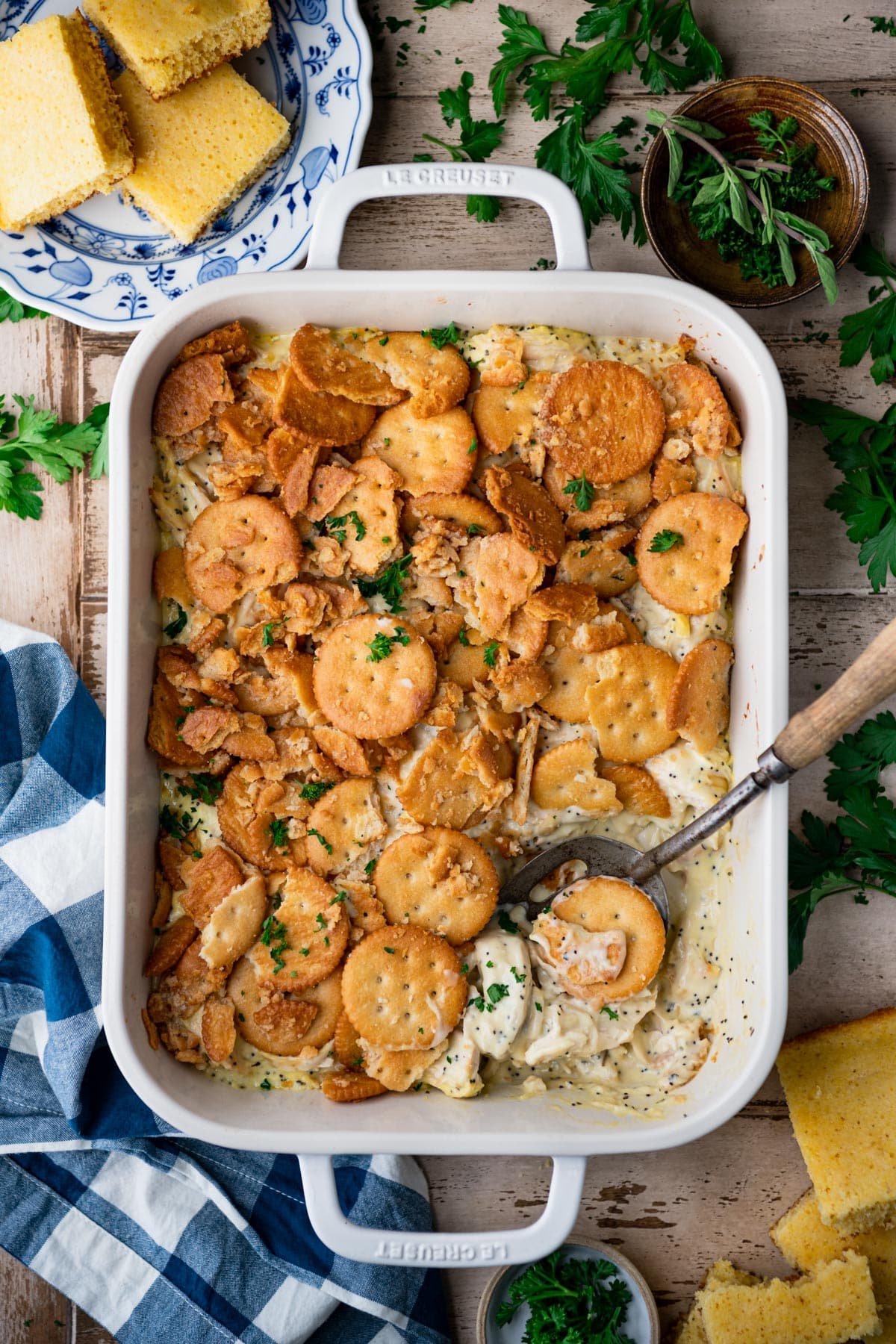 Chicken poppy seed casserole recipe in a white dish on a wooden table.