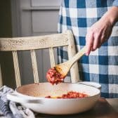 Stirring tomato paste into a pan