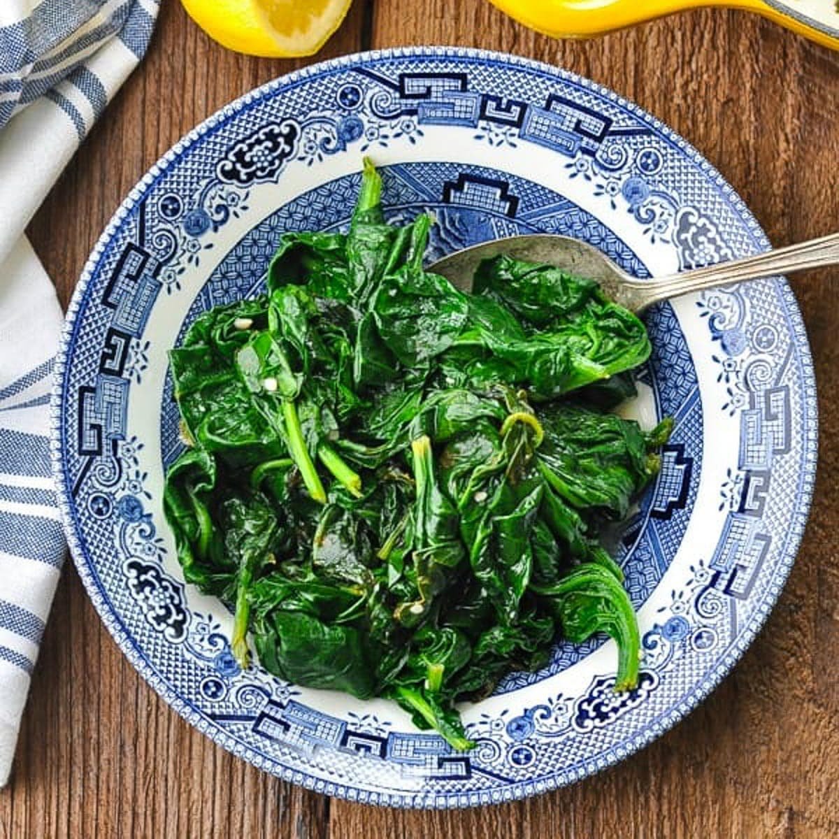 Plate of sauteed spinach with garlic and lemon.