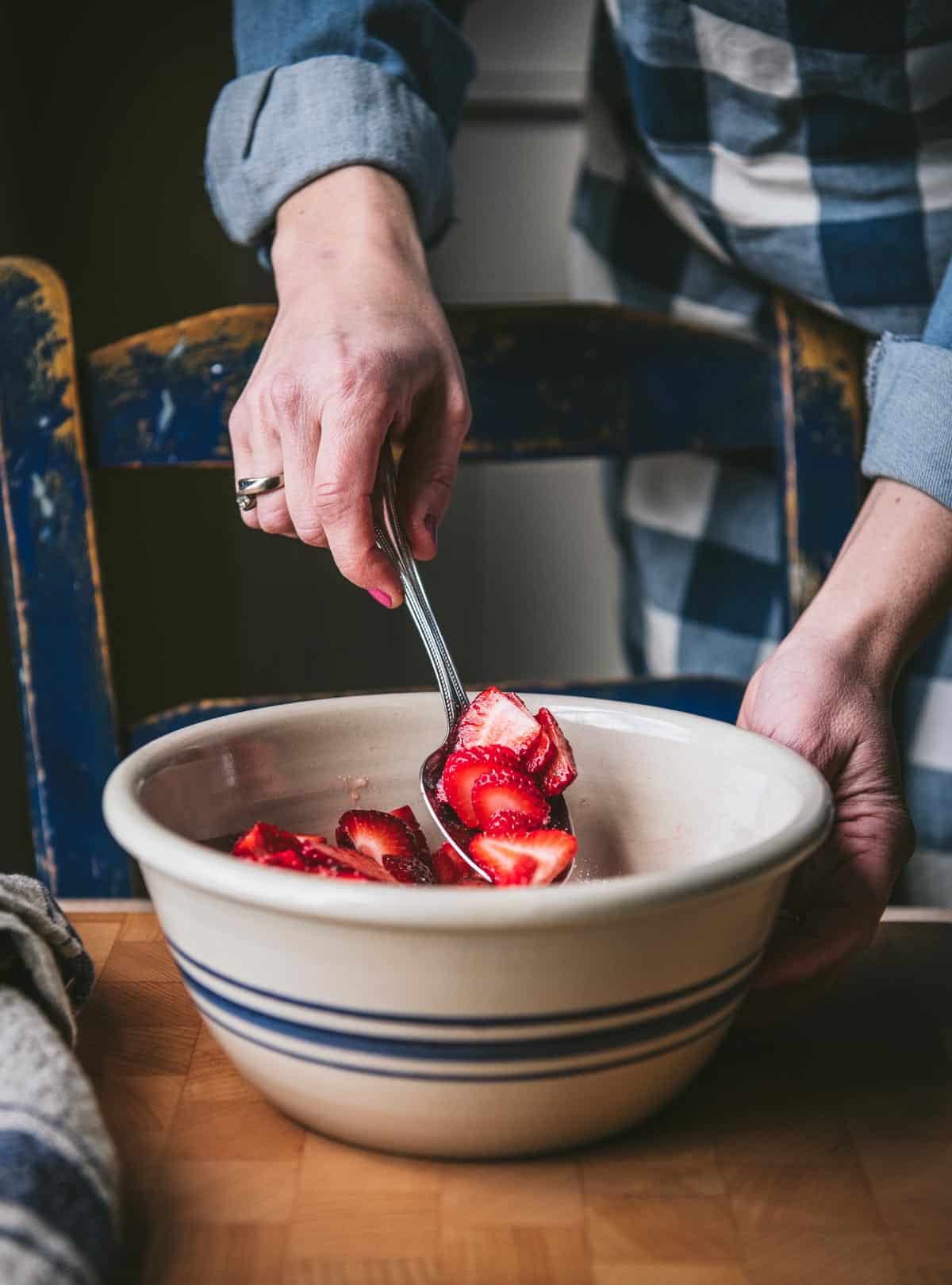 Stirring together sliced strawberries for shortcake recipe.
