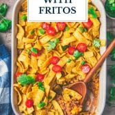 Overhead image of a pan of taco bake with fritos and text title overlay