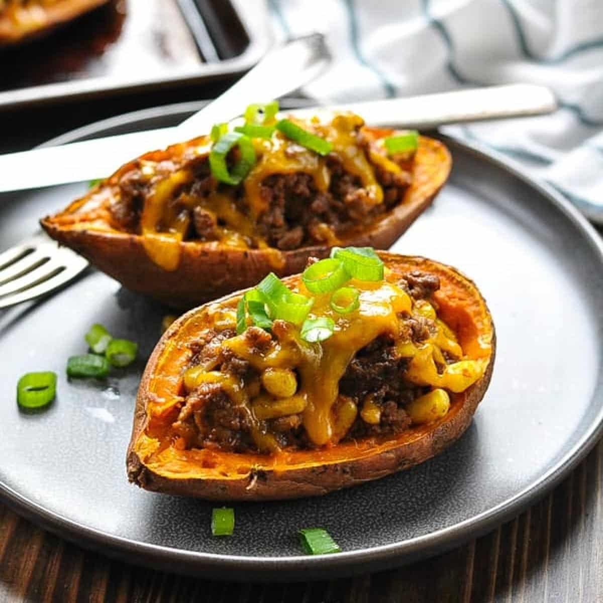 Square side shot of taco stuffed potatoes on a gray plate.