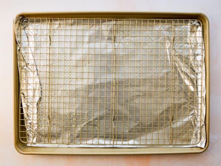 Arranging a wire rack on top of a rimmed baking sheet.