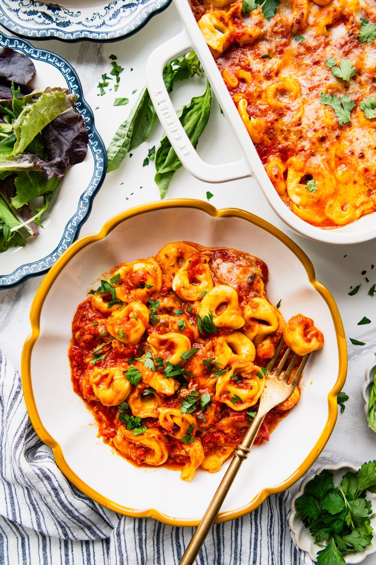 Overhead shot of a bowl of cheesy baked tortellini.