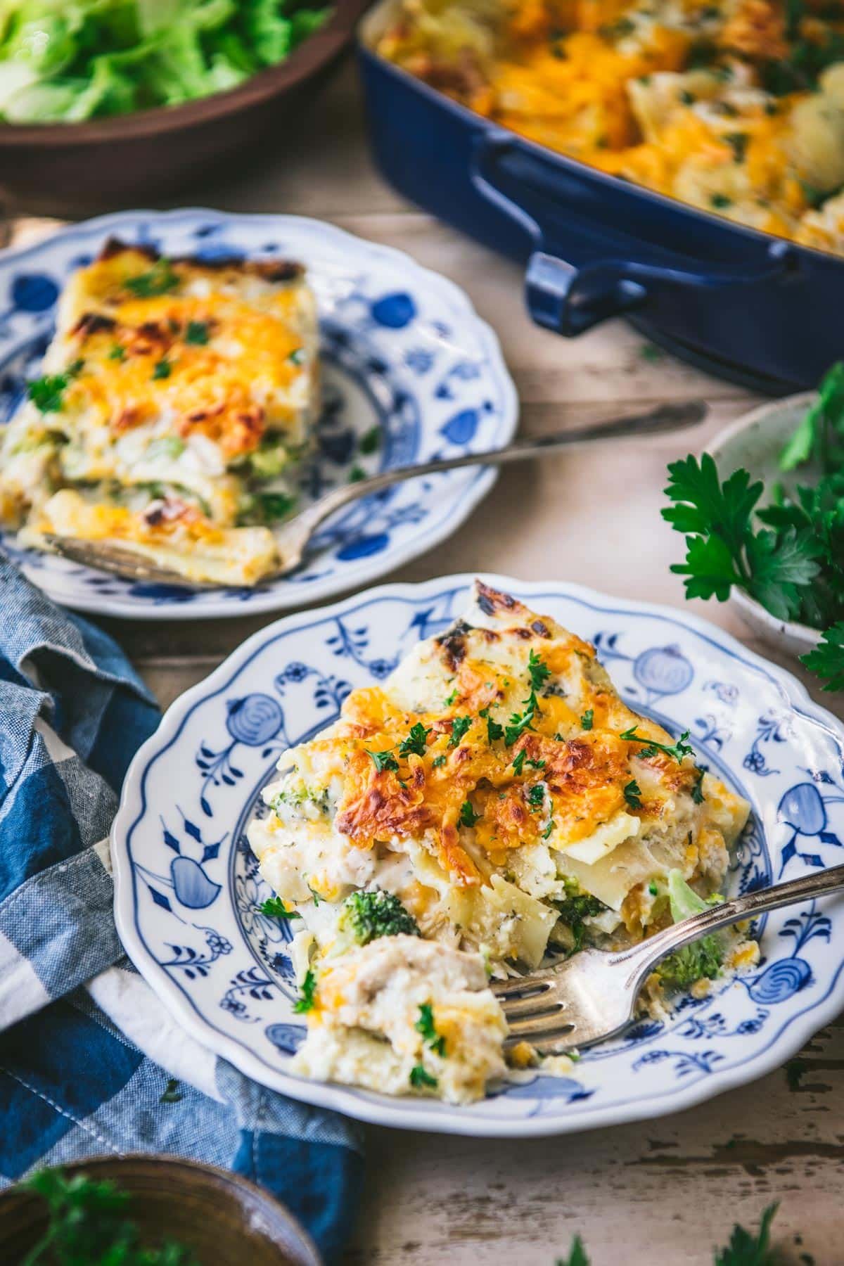 Two plates of cheddar chicken broccoli lasagna recipe.