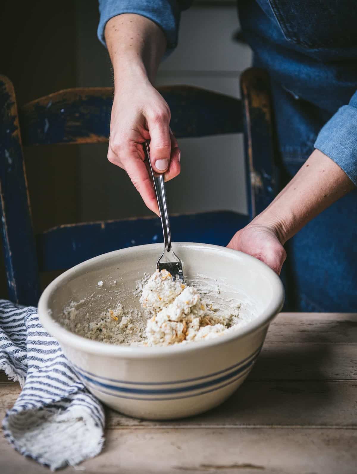 Stirring biscuit dough in a bowl.