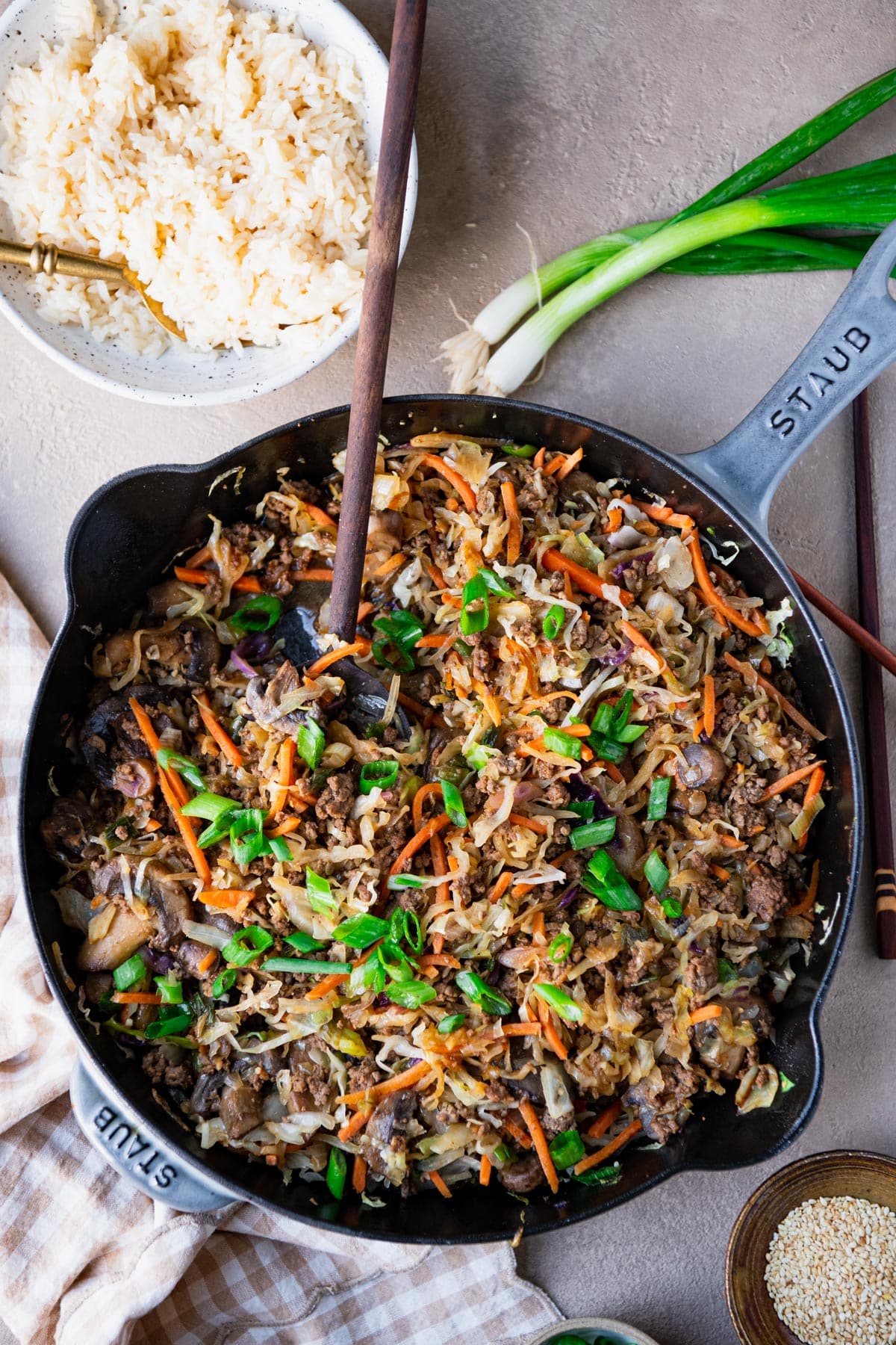Wooden spoon in a skillet of the best ground beef stir fry recipe.