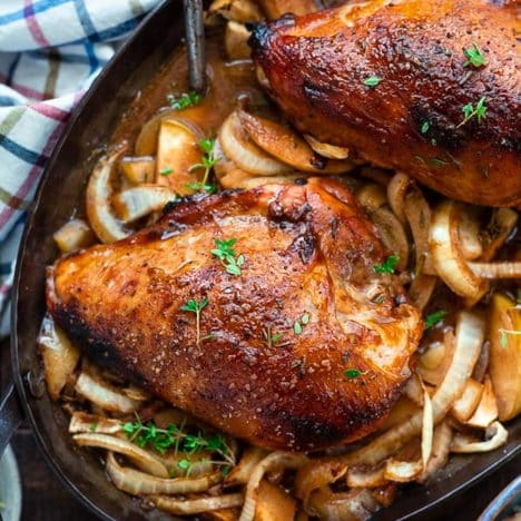 Square overhead shot of a pan of roasted chicken breast with apples and onions
