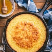 Overhead shot of cornbread with sour cream in a cast iron skillet.