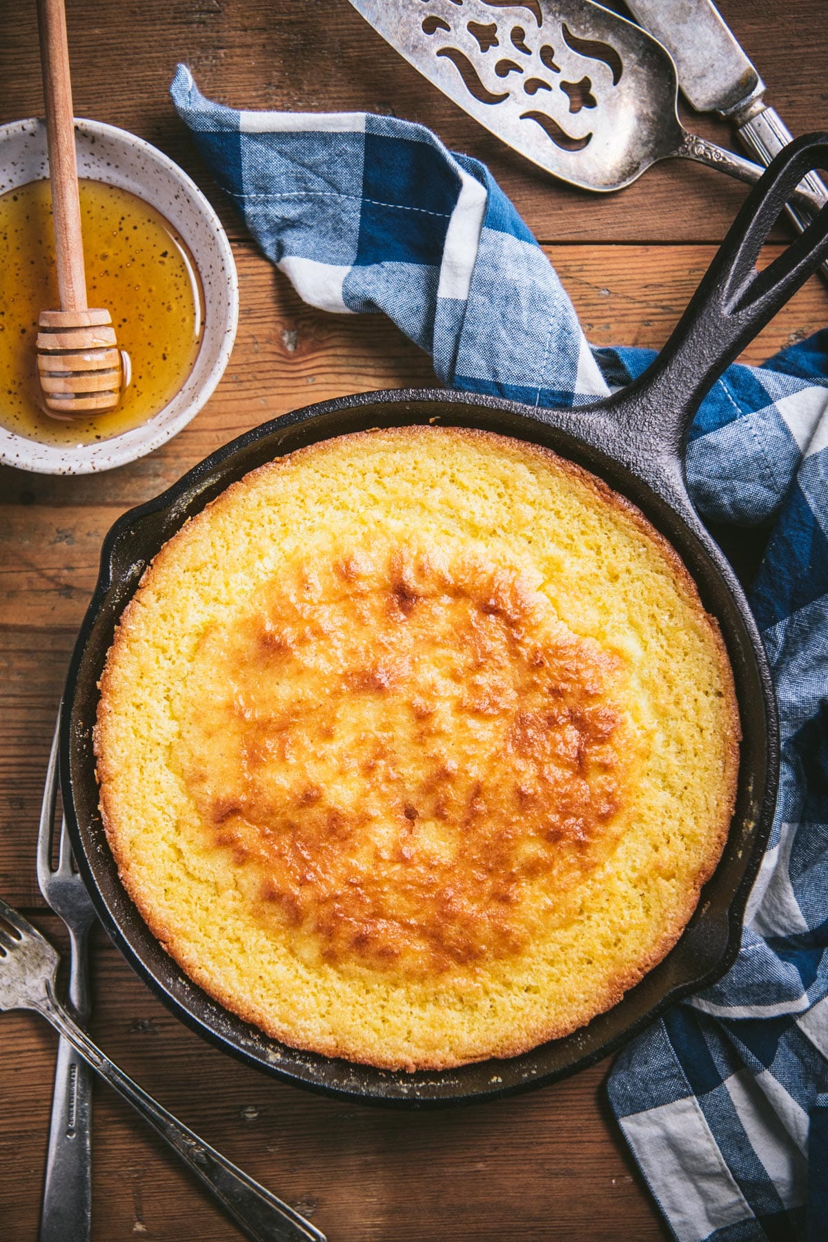 Overhead shot of cornbread with sour cream in a cast iron skillet.