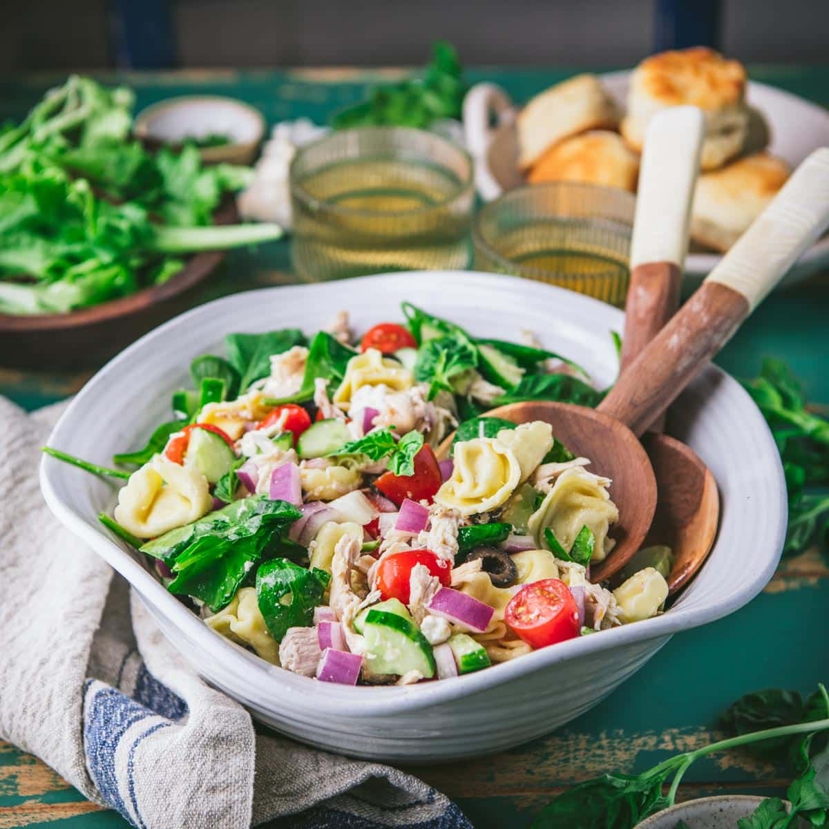Square side shot of tortellini pasta salad in a white bowl.