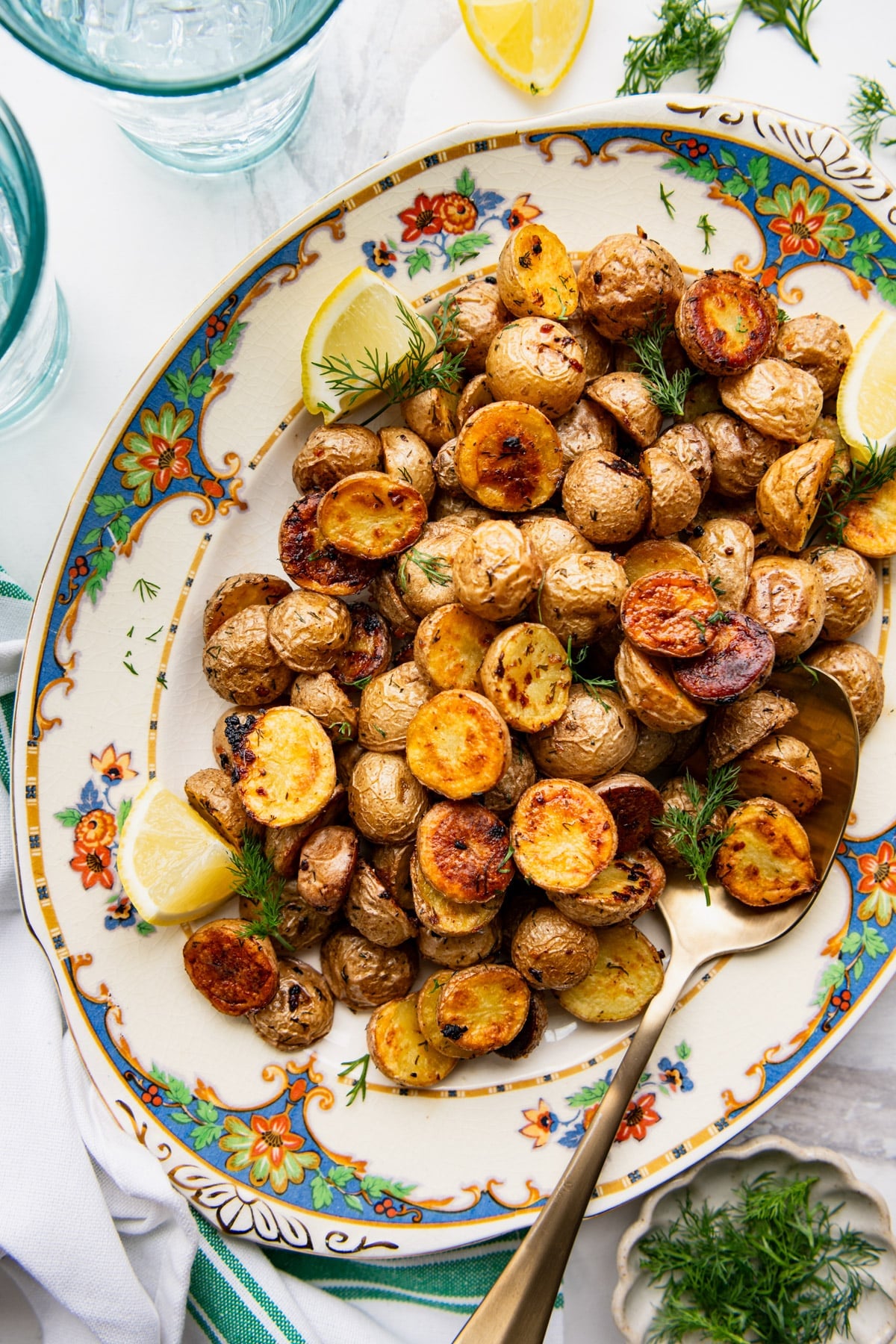 Close overhead image of a platter of dill roasted potatoes.