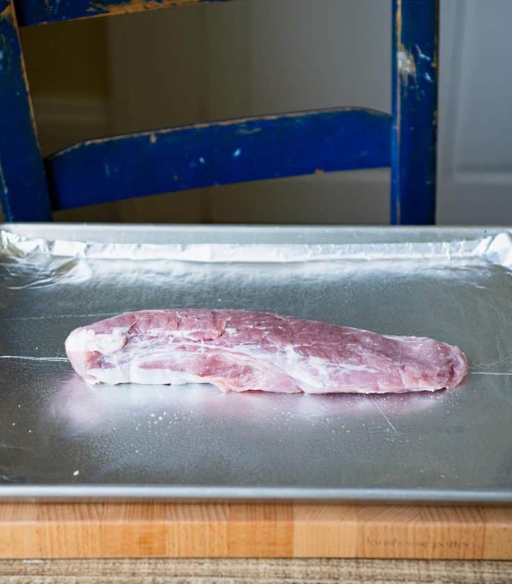 Pork tenderloin on a baking sheet.