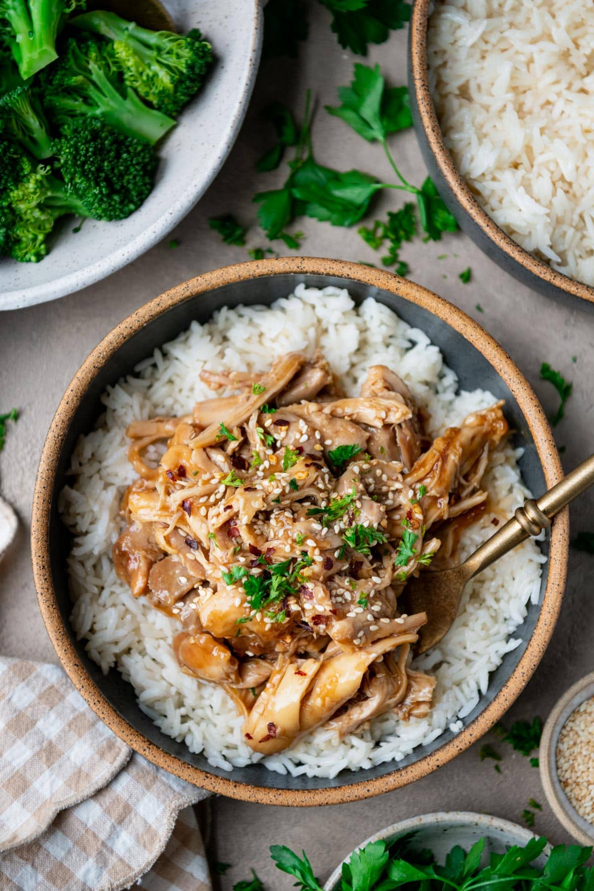 Overhead image of a fork in a bowl of crock pot maple soy chicken over rice.