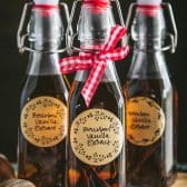Close up front shot of homemade bourbon vanilla extract in glass bottles.