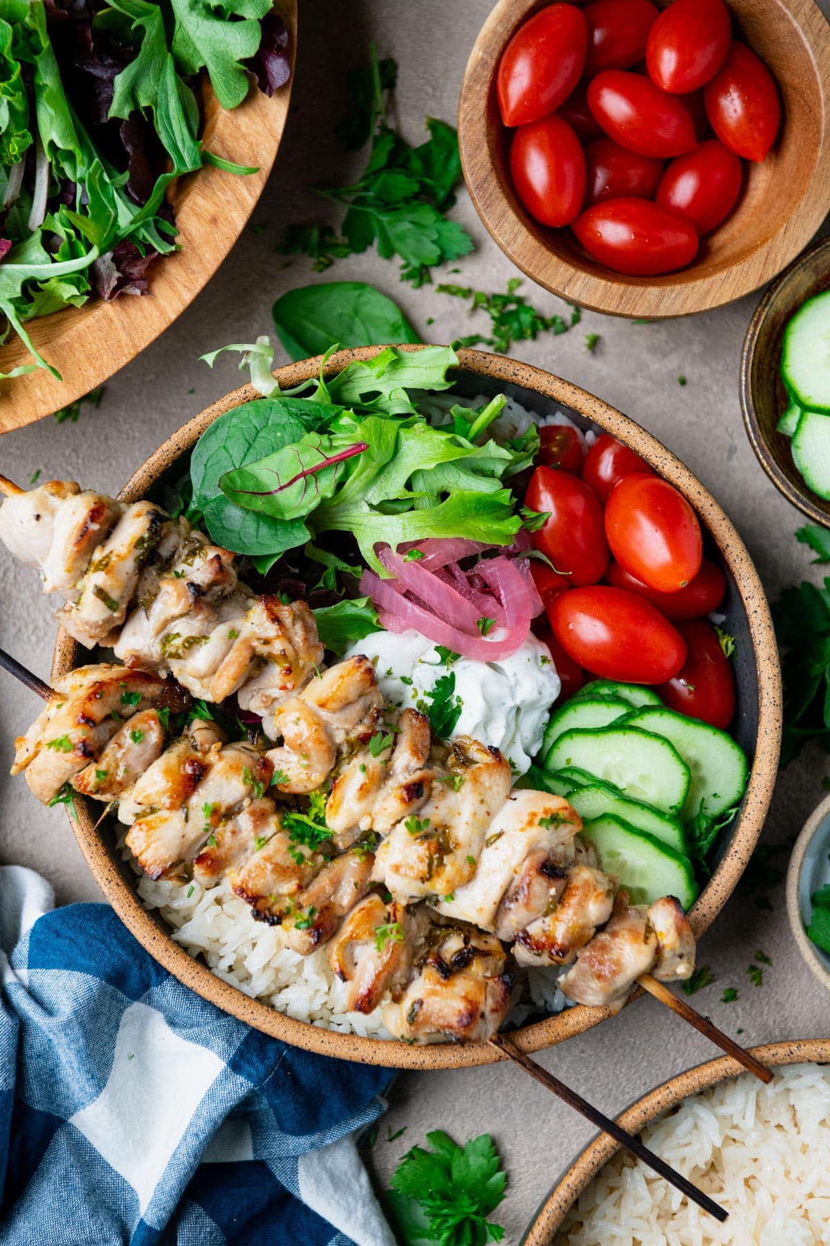 Chicken in a lemon garlic marinade served on kabob skewers over a bowl of rice.