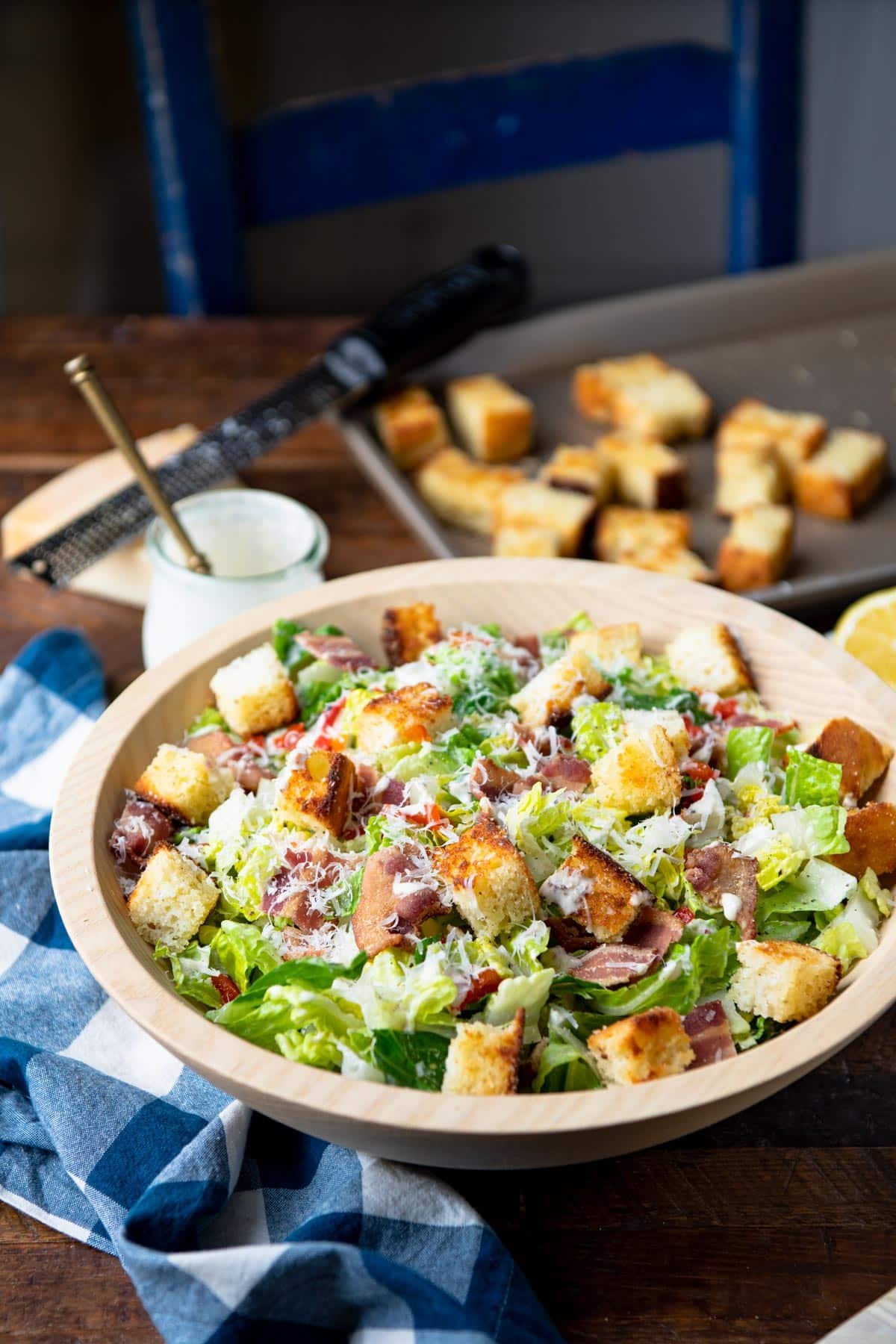 Side shot of Southern Caesar salad with cornbread croutons in the background.